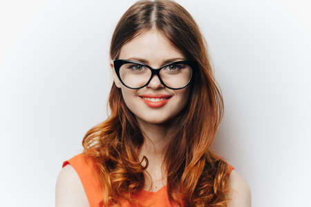 Business woman in orange shirt with notepad in hands fashion glasses