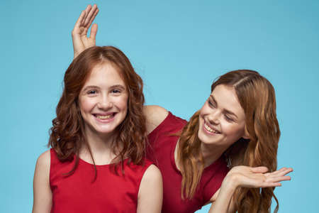 Family mom and daughter hug red dresses communication emotions blue background