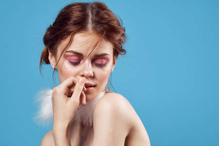 attractive woman with naked shoulders wearing earrings.  blue backgroundの写真素材