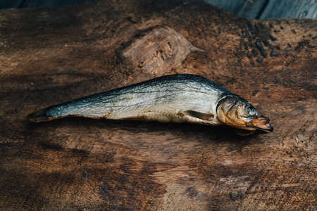 dried fish lies on a wooden table top view texture background image