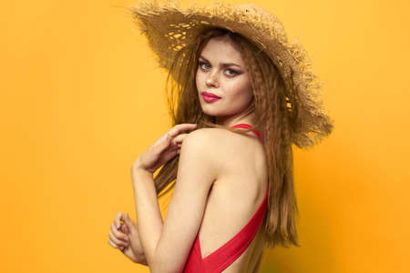Woman in straw hat bright makeup summer lifestyle fun yellow backgroundの写真素材