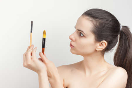 woman applying makeup brush on face skin careの写真素材