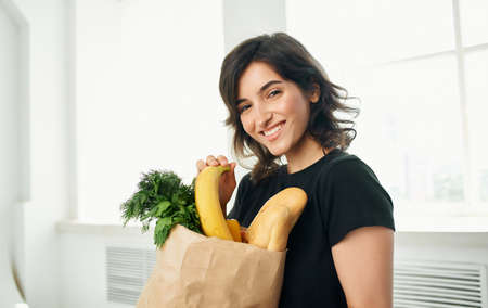 brunette in black t-shirts package with groceries shopping healthy foodの写真素材