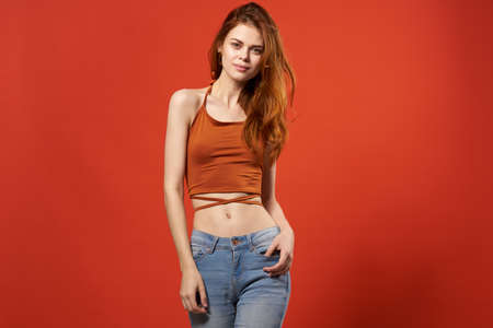 pretty woman in red t shirt and jeans street fashion attractive look smile red backgroundの写真素材