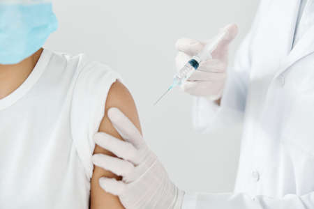 doctor and patient wearing medical masks covid-19 injection vaccination infectionの写真素材