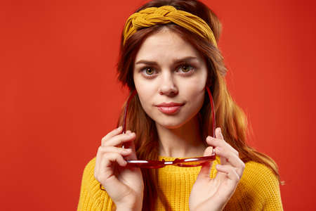 attractive woman yellow sweater fashionable clothing street style red backgroundの写真素材