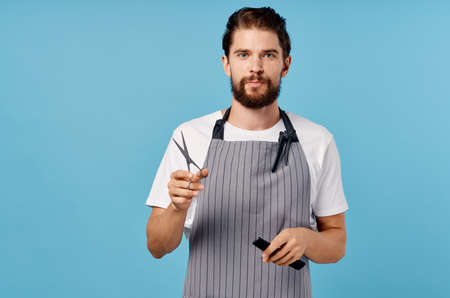 cute hairdresser with a beard holds scissors and a comb in his hands hairstyle barbershop modelの写真素材