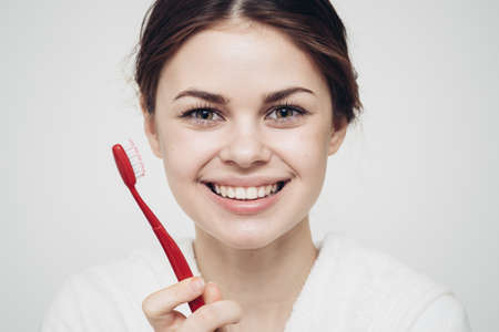 pretty woman in white robe brushing tongue hygieneの写真素材