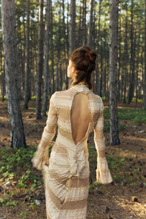 Forest woman in dress outdoors in park in autumnの写真素材