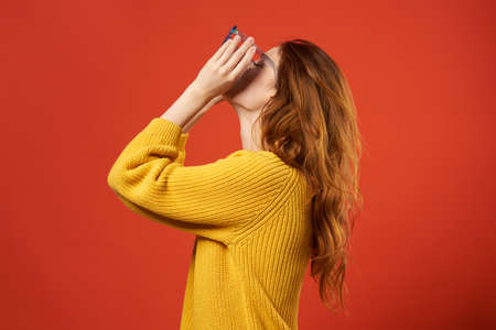 pretty woman in yellow sweater glasses attractive look cropped view red backgroundの写真素材
