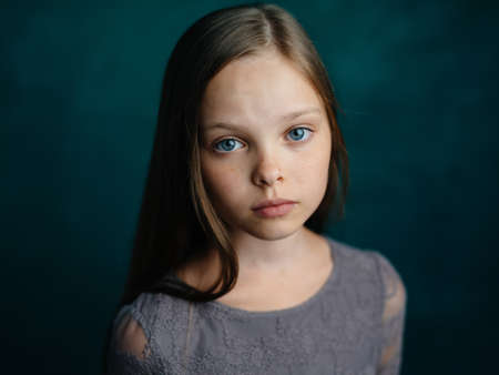 Pretty little girl in gray dress loose hair portrait cropped view.の写真素材