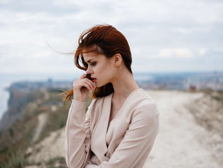 Romantic red-haired woman In a light sweater on the nature outdoorsの写真素材