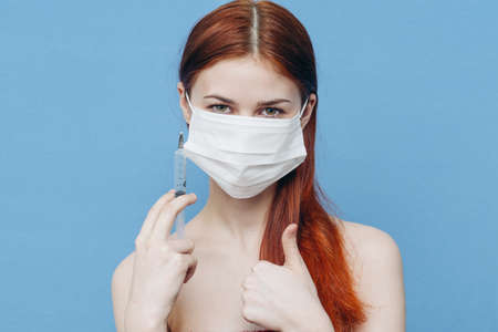 woman holding in hand on blue background naked shoulders model emotionsの写真素材