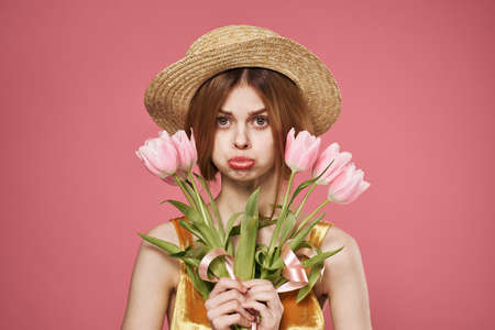 Cheerful woman in a hat bouquet of flowers holiday womens day on March 8の写真素材