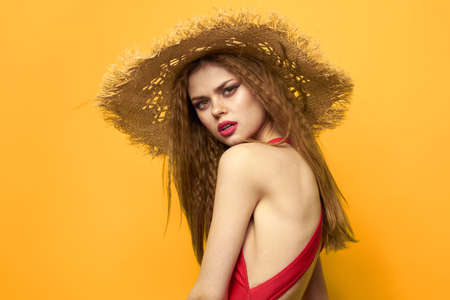 Cheerful pretty woman beach hat fun emotions yellow backgroundの写真素材