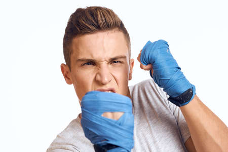 Sportive man boxing bandages on workout hands in gym exercises