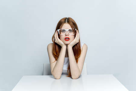 elegant woman in glasses sitting at the table red lips studio lifestyle