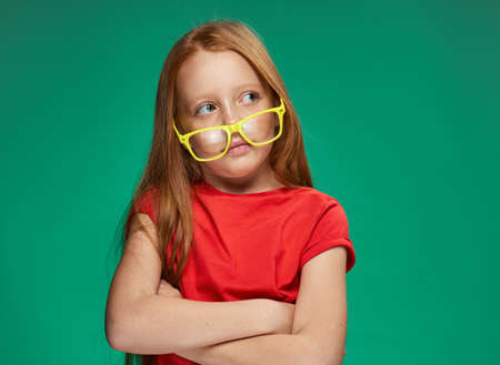 girl with red hair and glasses training school green backgroundの写真素材