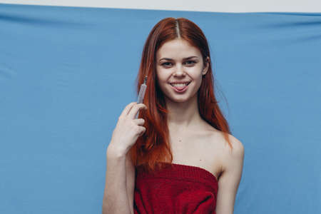 woman holding in hand on blue background naked shoulders model emotionsの写真素材