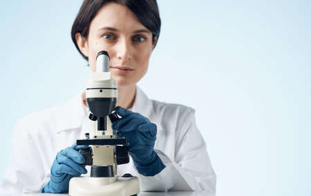 woman doctor in medical gloves and microscope on the table professional laboratoryの写真素材