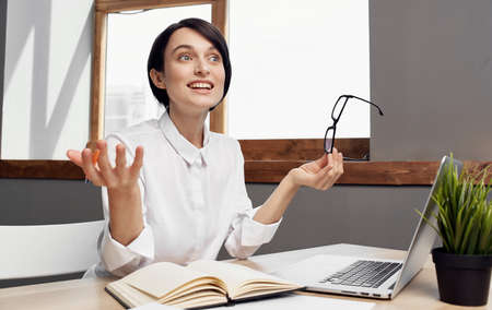Business woman sitting at work table in front of laptop finance office