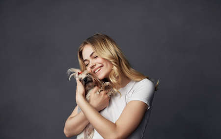 woman holding hands small purebred dog friendship hug joy gray backgroundの写真素材