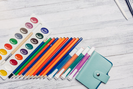stationery on wooden table card holder pencils and watercolor paintsの写真素材