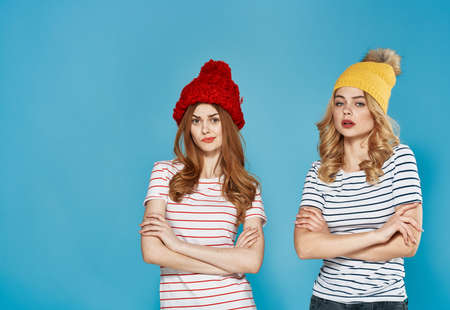 Women in multi-colored caps emotions discontent quarrel conflict blue backgroundの写真素材