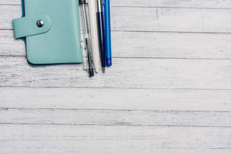 business card holder and pens pencils on a wooden table office financeの写真素材