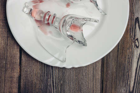 broken glass of wine kitchenware white plate wooden table shardsの写真素材