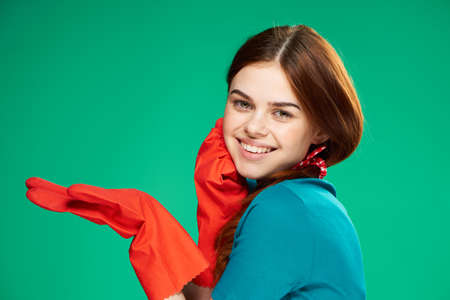 cheerful pretty woman in rubber gloves emotions green background cleaningの写真素材