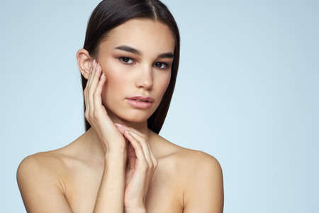 Woman with naked shoulders long hair clean skin cropped view blue backgroundの写真素材