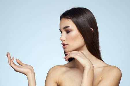 Woman with naked shoulders long hair clean skin cropped view blue backgroundの写真素材
