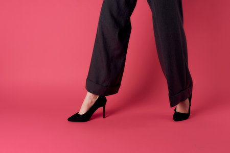 female legs black shoes glamor luxury pink background cropped viewの写真素材