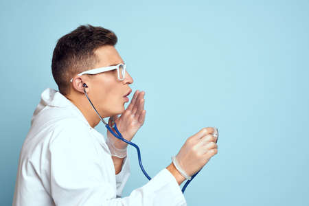 Male doctor white coat treatment medical instruments blue background