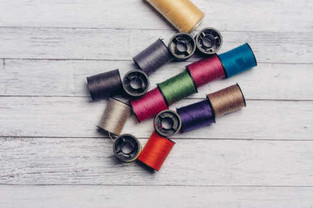 sewing accessories colored threads top view wooden backgroundの写真素材