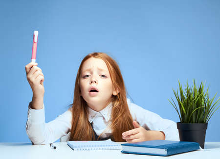 red-haired girl sitting at study table education lifestyle learningの写真素材