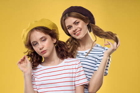 Mom and daughter embrace joy fun childhood lifestyle yellow backgroundの写真素材