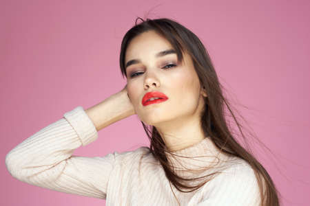 Beautiful brunette red lips white blouse close-up attractive view pink backgroundの写真素材