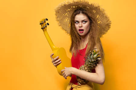 Woman holding Ukulele straw hat lifestyle Exotic yellow background