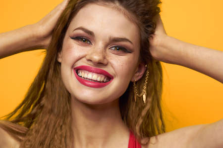 emotional woman wavy hair bright makeup lifestyle yellow background