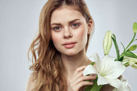 Emotional woman with flowers spring model naked shoulders clear skinの写真素材