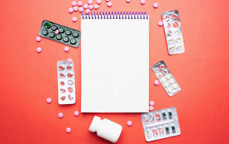 multicolored medicine medicine red background first aid kit