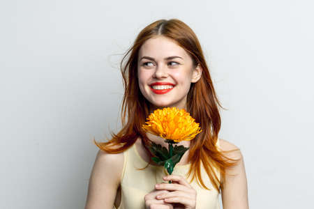 smiling woman with big yellow flower in hands emotions joy studio