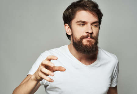 emotional man gesturing with his hands on a light background aggression screamの写真素材