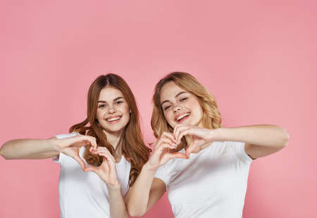 two girls emotions studio communication lifestyle pink backgroundの写真素材