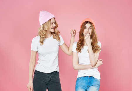 Cute fashionable girlfriends wearing lifestyle hats Glamor pink backgroundの写真素材