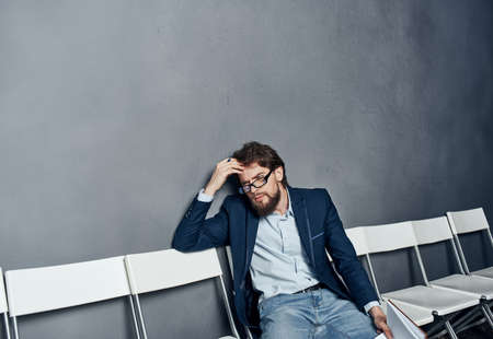 A man in a suit waiting for a job interview trying emotionsの写真素材