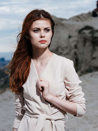 A woman in light clothes travels in nature near the rocks in the mountainsの写真素材