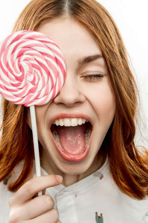 woman with open mouth holds lollipop near face Sweets joy emotionsの写真素材